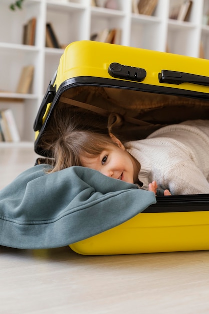 Medium shot girl sitting in luggage