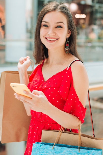 Foto gratuita ragazza del colpo medio che sorride alla macchina fotografica