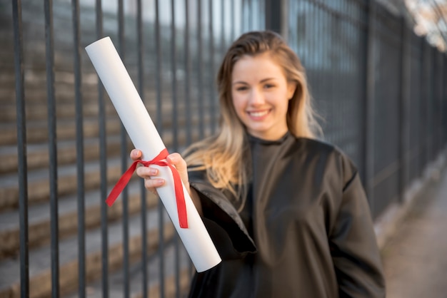 Medium shot girl smiling holding her certificate 