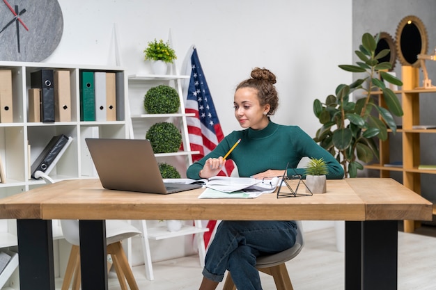 Medium shot girl studying at desk indoors