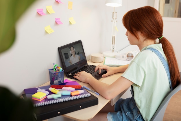 Free photo medium shot girl typing at home