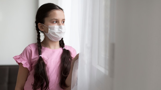 Medium shot girl wearing medical mask