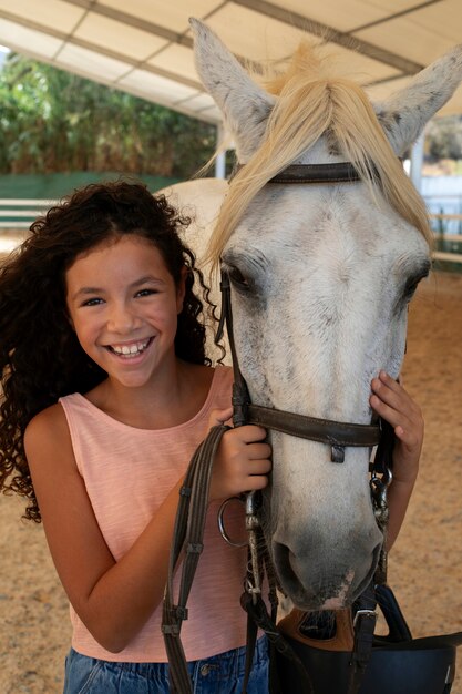 Бесплатное фото Средняя девушка с красивой лошадью.