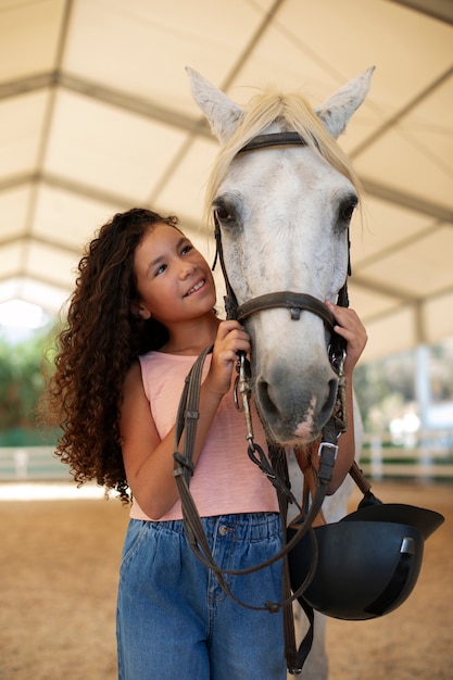 Foto gratuita ragazza di taglio medio con un bellissimo cavallo