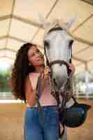 Foto gratuita ragazza di taglio medio con un bellissimo cavallo