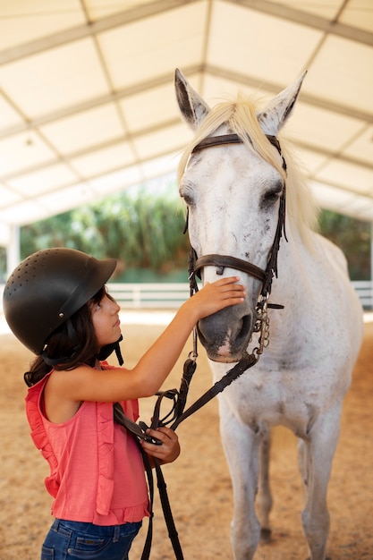 Medium shot girl with beautiful horse