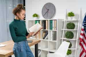 Free photo medium shot girl with a book indoors