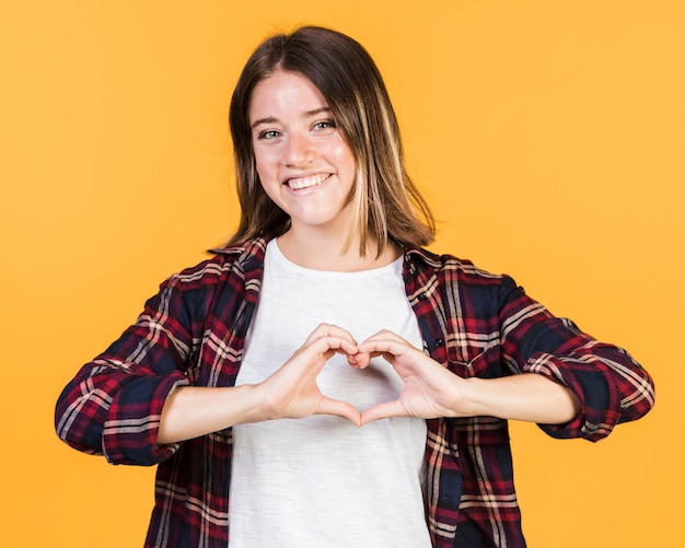 Foto gratuita ragazza a mezzo colpo con le mani a forma di cuore