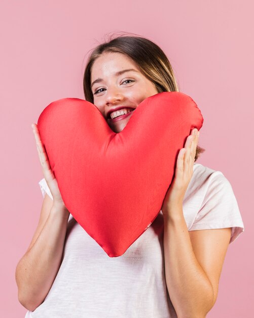 Medium shot girl with heart shaped pillow