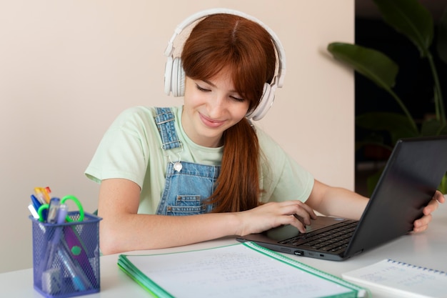 Medium shot girl with laptop at home