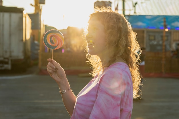 Medium shot girl with lollipop and sunshine