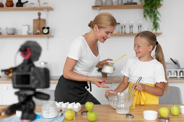 Medium shot girl and woman preparing food