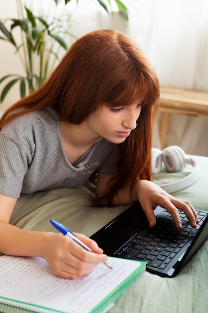 Medium shot girl working with laptop