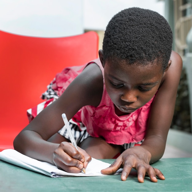 Medium shot girl writing on notebook