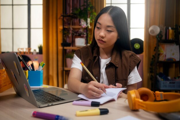 Medium shot girl writing in notebook