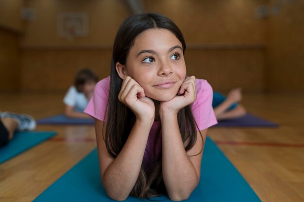 Medium shot girl on yoga mat