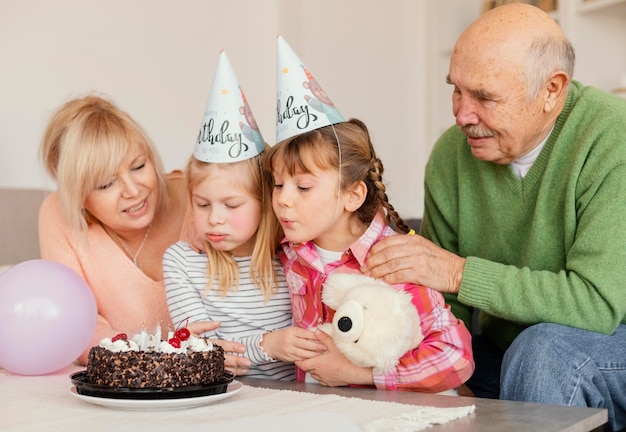 Medium shot girls blowing candles