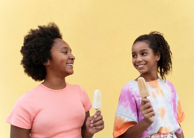 Foto gratuita ragazze di tiro medio che tengono il gelato