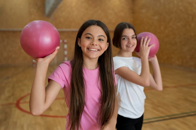 Medium shot girls holding pink balls