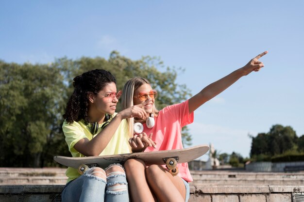 Medium shot girls holding skateboard