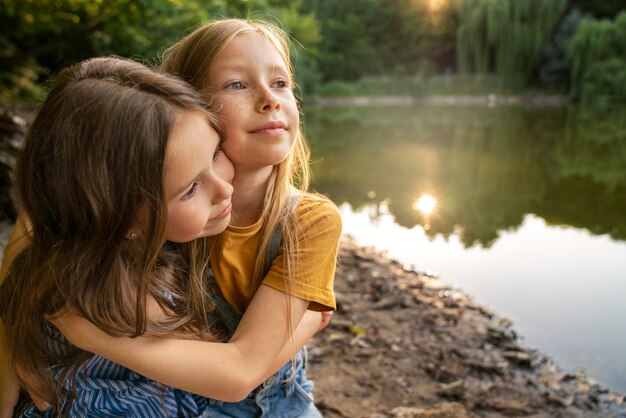 Medium shot girls hugging outdoors