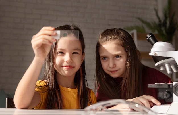 Medium shot girls looking at glass slide