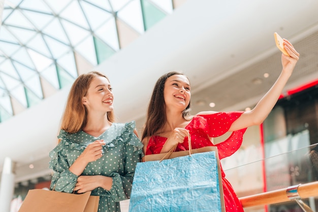 Medium shot girls at mall taking a selfie