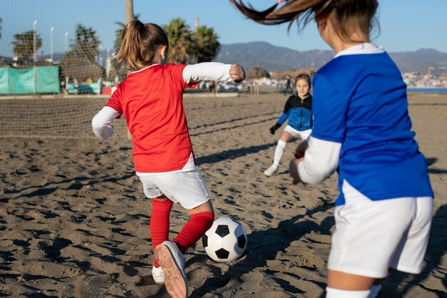 Medium shot girls playing football together