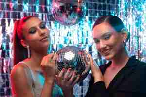 Free photo medium shot girls posing with disco ball