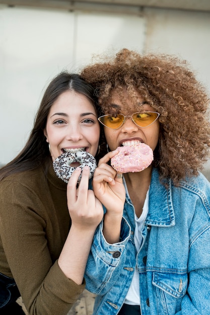 Free photo medium shot girls with doughnuts