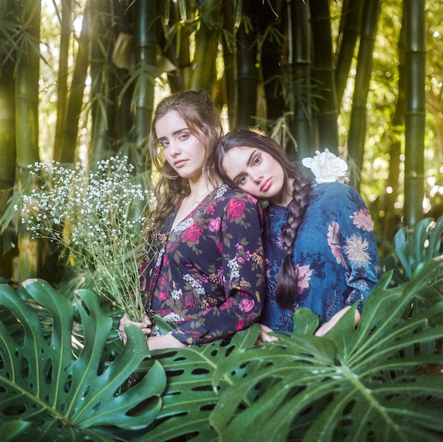 Medium shot of girls with monstera leaves