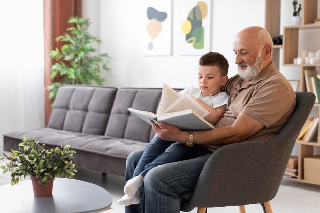 Дедушка среднего размера читает ребенку