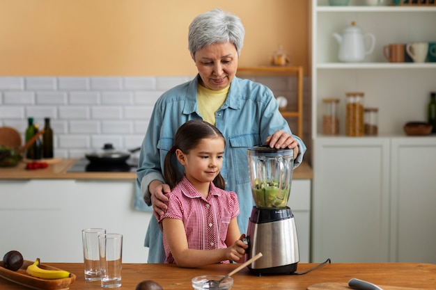 Medium shot grandma and girl cooking together