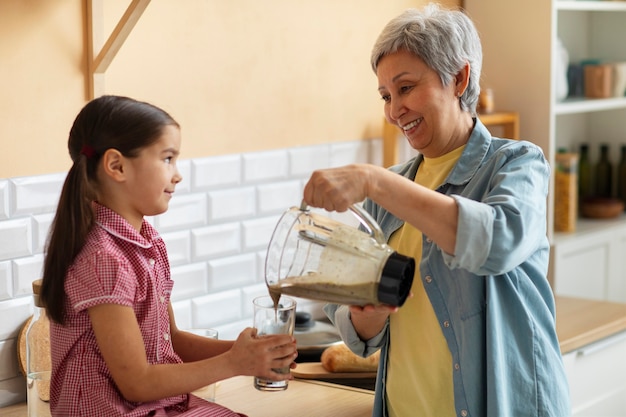 Medium shot grandma and girl cooking together