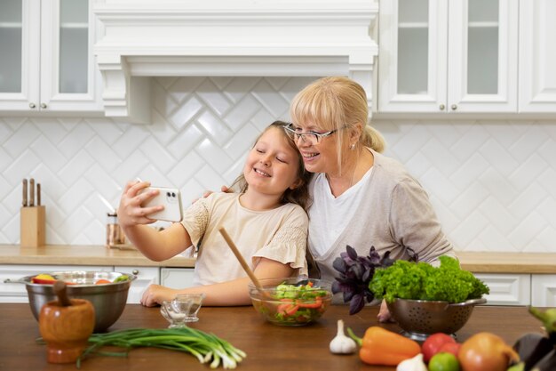 Medium shot grandma and kid taking selfie