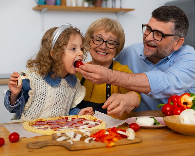 ミディアムショットの祖父母とキッチンの女の子