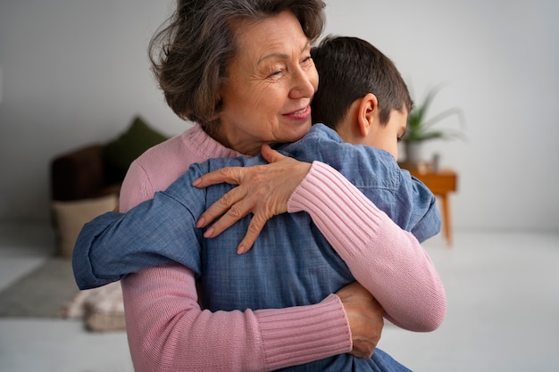 Free photo medium shot grandson and grandmother indoors