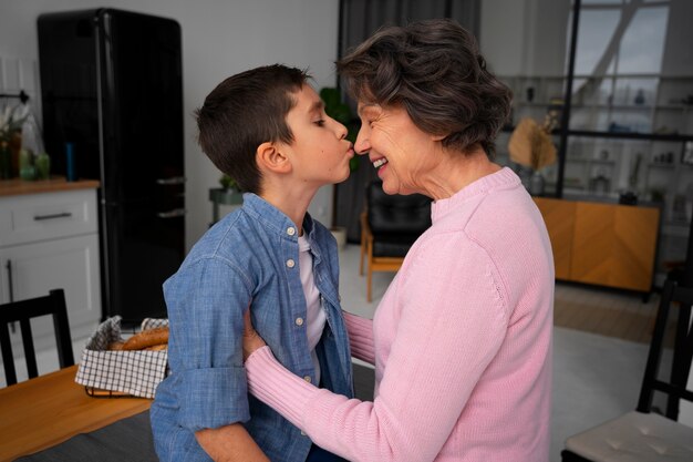 Внук среднего плана целует бабушку