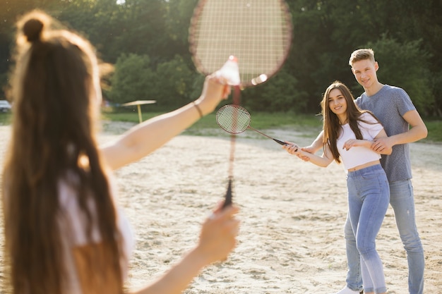 Medium shot group of friends playing badminton