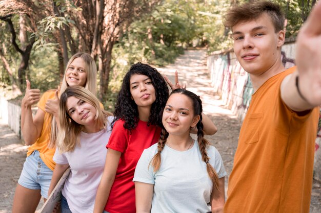 Gruppo di amici del colpo medio che prendono selfie