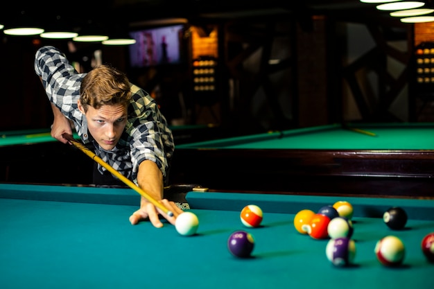 Medium shot guy holding pool cue 