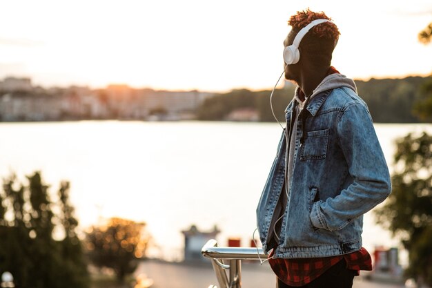 Medium shot guy with headphones and jeans jacket