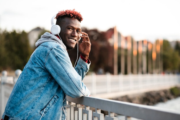 Free photo medium shot guy with headphones near the lake