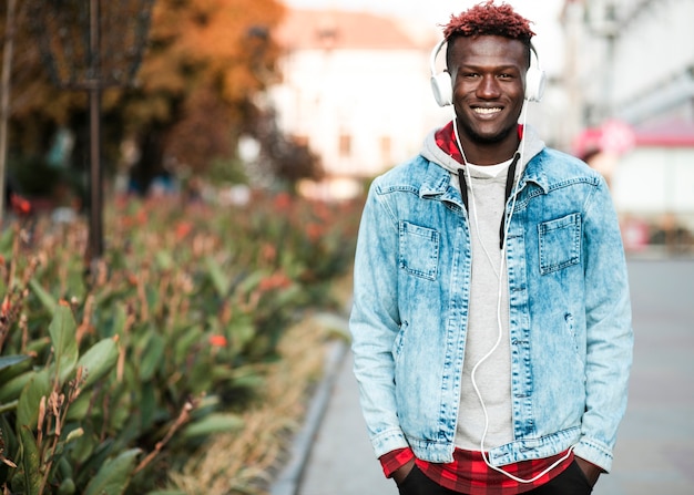 Medium shot guy with headphones posing outdoors