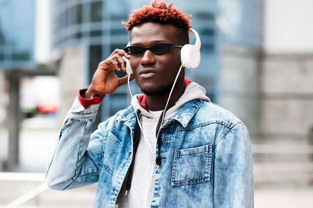 Medium shot guy with headphones and sunglasses