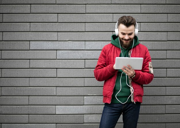 ヘッドフォンとタブレットでミディアムショットの男