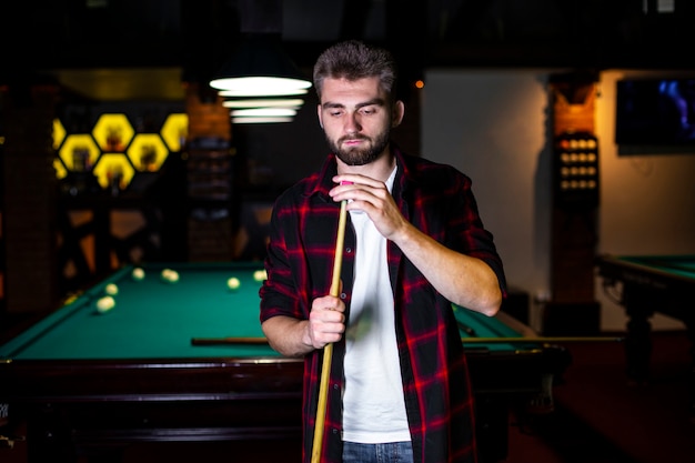 Medium shot guy with pool cue and chalk 