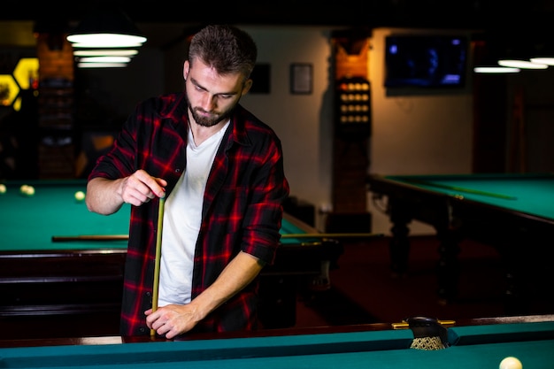 Medium shot guy with pool cue and chalk