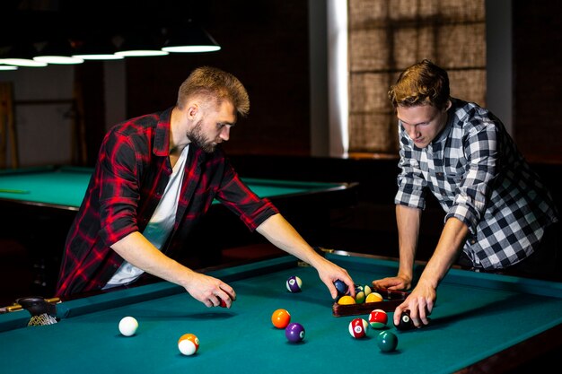 Medium shot guys arranging pool balls