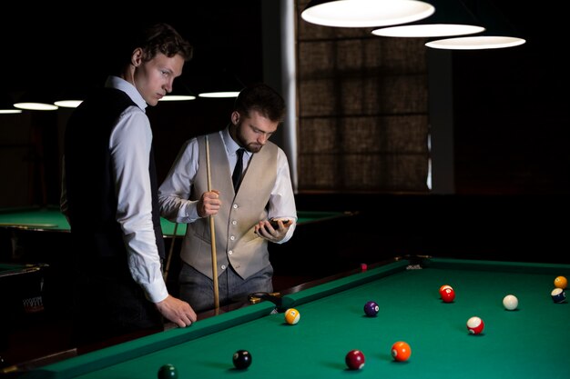 Medium shot guys at billiard club with smartphones